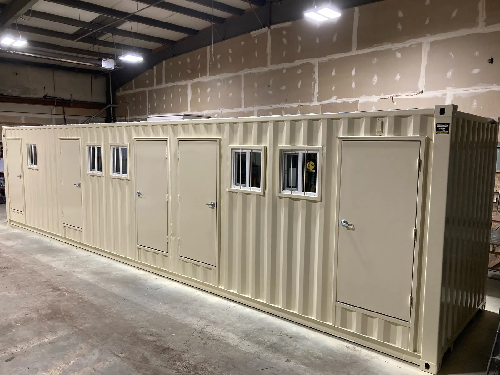 One side of a custom 8-by-40-foot unit with multiple installed doors and windows