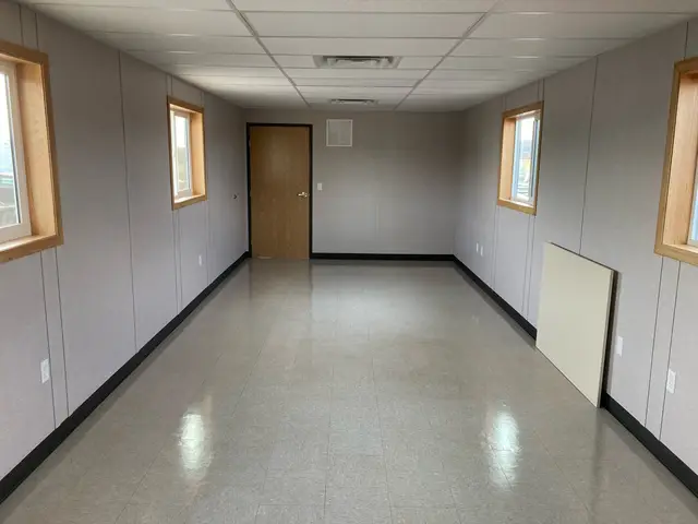 Private office area inside MO-95 with multiple windows, interior door, and finished resilient flooring