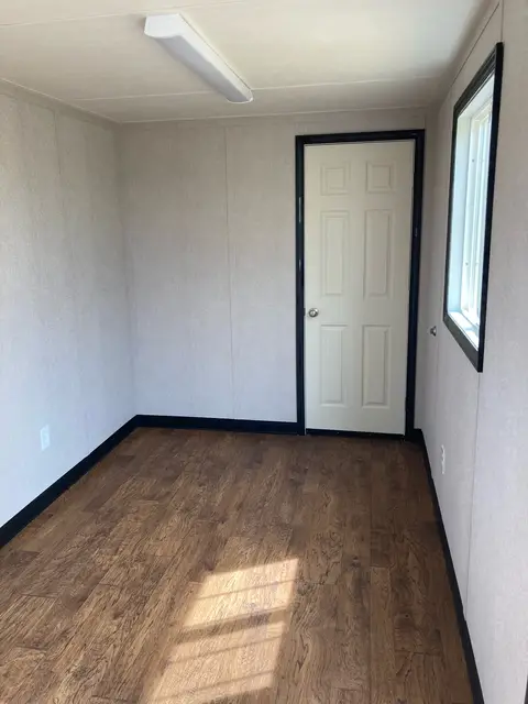 Finished office area inside OS-362 with wood-look flooring, window, lighting, outlets, and interior storage door