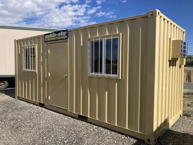 O-366 8 by 20 foot on-ground office exterior with personnel door, two barred windows, and wall-mounted air conditioner