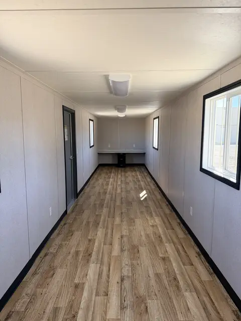 Open 40-foot interior workspace inside O-370 with wood-look flooring, multiple windows, lighting, outlets, and workstation