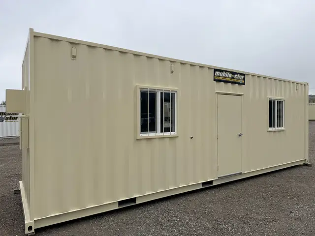 Front exterior of the O-372 8 by 30 foot on-ground office with personnel door and two windows