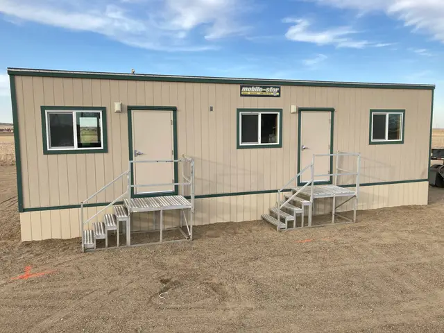 Tan and green dual-entry mobile office installed with aluminum stairs