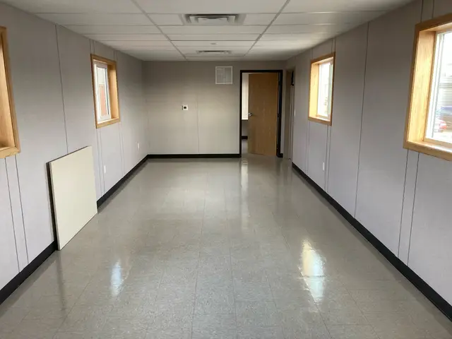 Spacious finished mobile office interior with windows, lighting, and HVAC