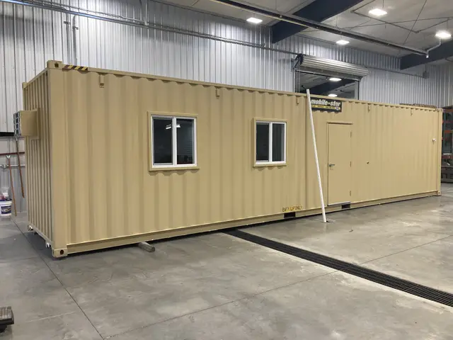 Container interior prepared for modification with personnel door and exposed steel walls