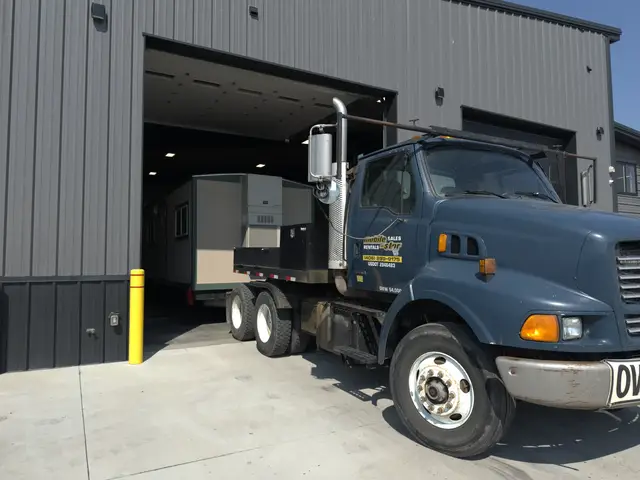 Three-quarter view of Mobile-Stor's branded blue delivery truck at the shop entrance