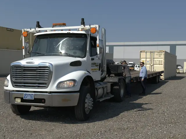Front view of a Mobile-Stor delivery truck and tilt-bed trailer