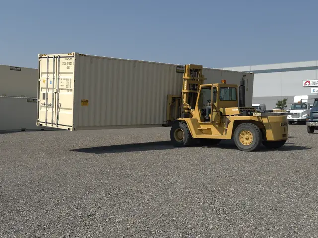 Forklift lifting a shipping container for placement in the yard