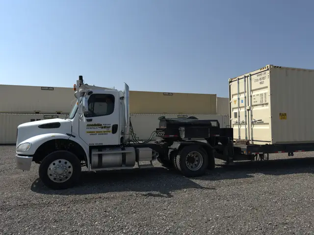 Mobile-Stor delivery truck positioned beside a shipping container in the Billings yard